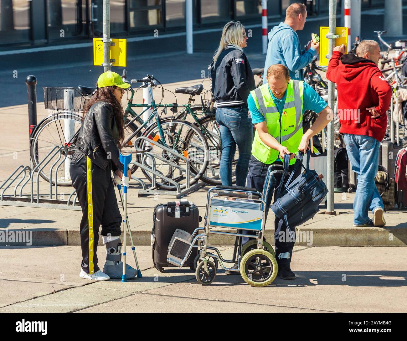 BERLIN, GERMANY, 20 MAY 2018: Assistant helping woman on a wheelchair getting to the bus station near the Schonefeld Airport Terminal Stock Photo