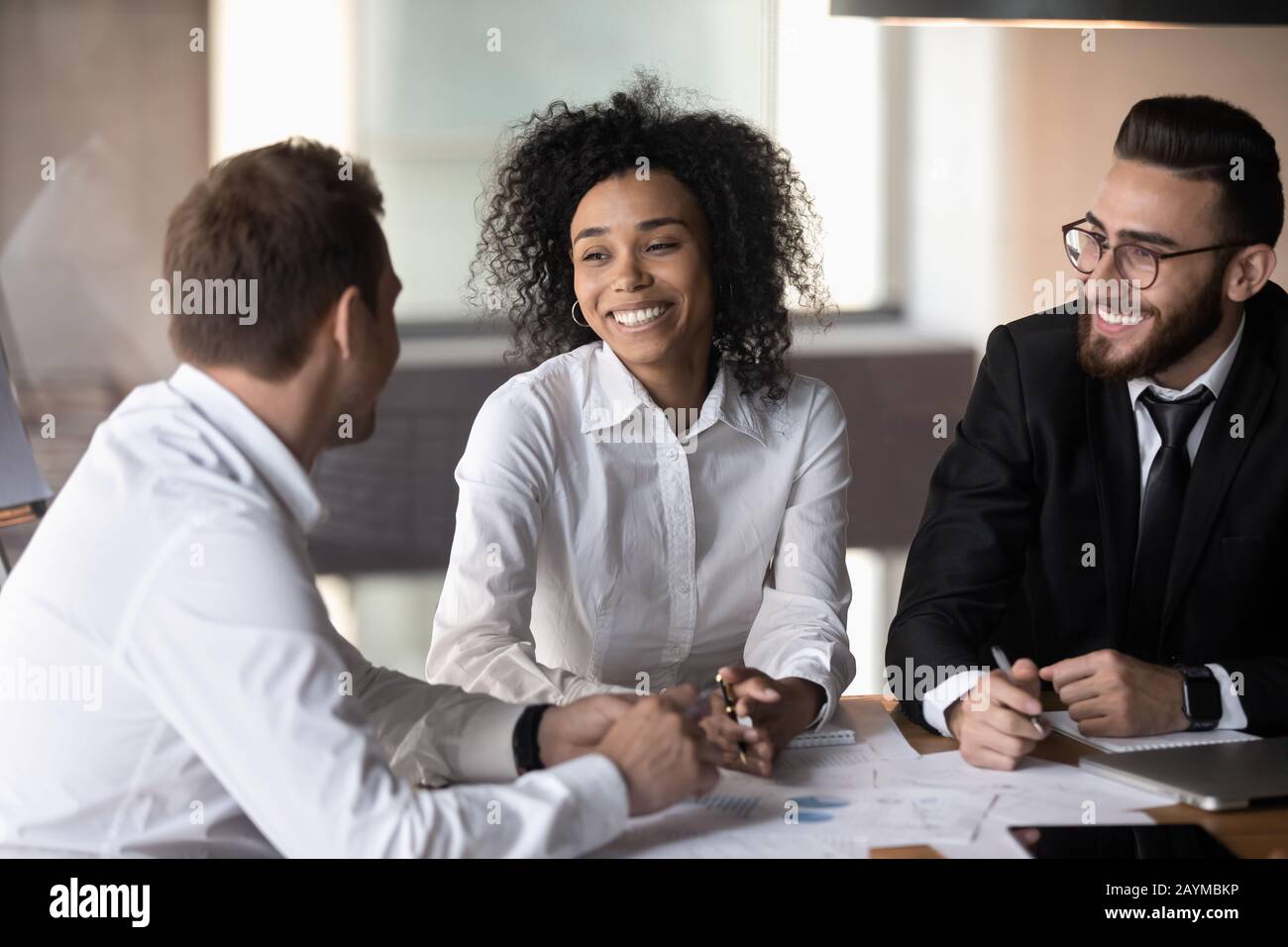 Three diverse professionals working together on new profitable project Stock Photo