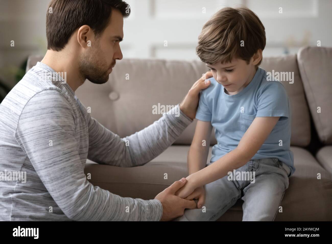 Kind daddy supporting depressed offended small boy. Stock Photo