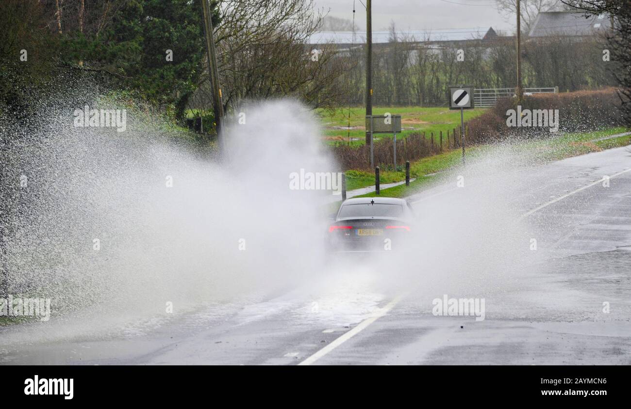 Albourne Sussex UK 16th February 2020 - A car drives through floodwater on the B2118 at Albourne jus north of Brighton as Storm Dennis continues to cause problems throughout the country  . Credit: Simon Dack / Alamy Live News Stock Photo