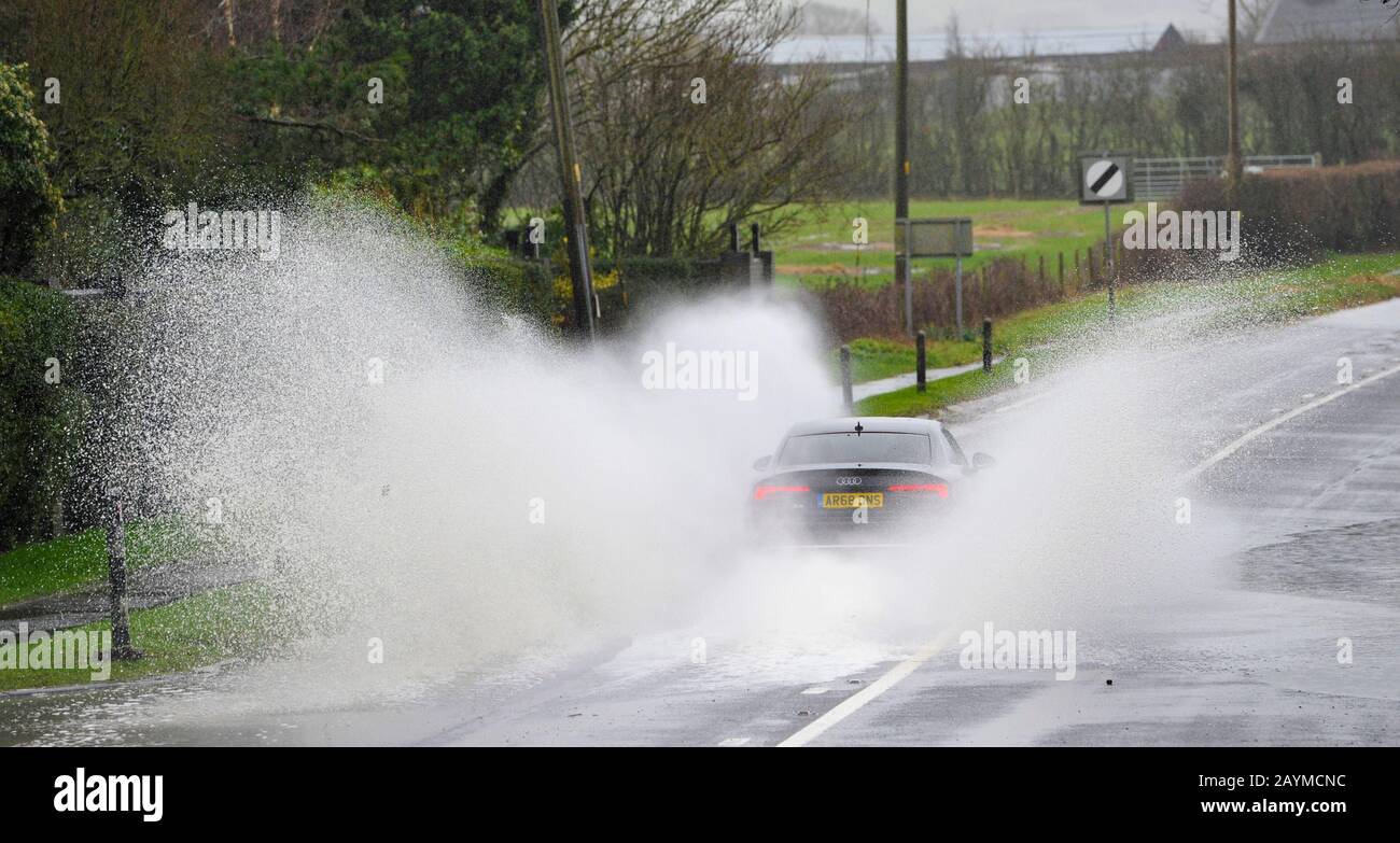 Albourne Sussex UK 16th February 2020 - A car drives through floodwater on the B2118 at Albourne jus north of Brighton as Storm Dennis continues to cause problems throughout the country  . Credit: Simon Dack / Alamy Live News Stock Photo