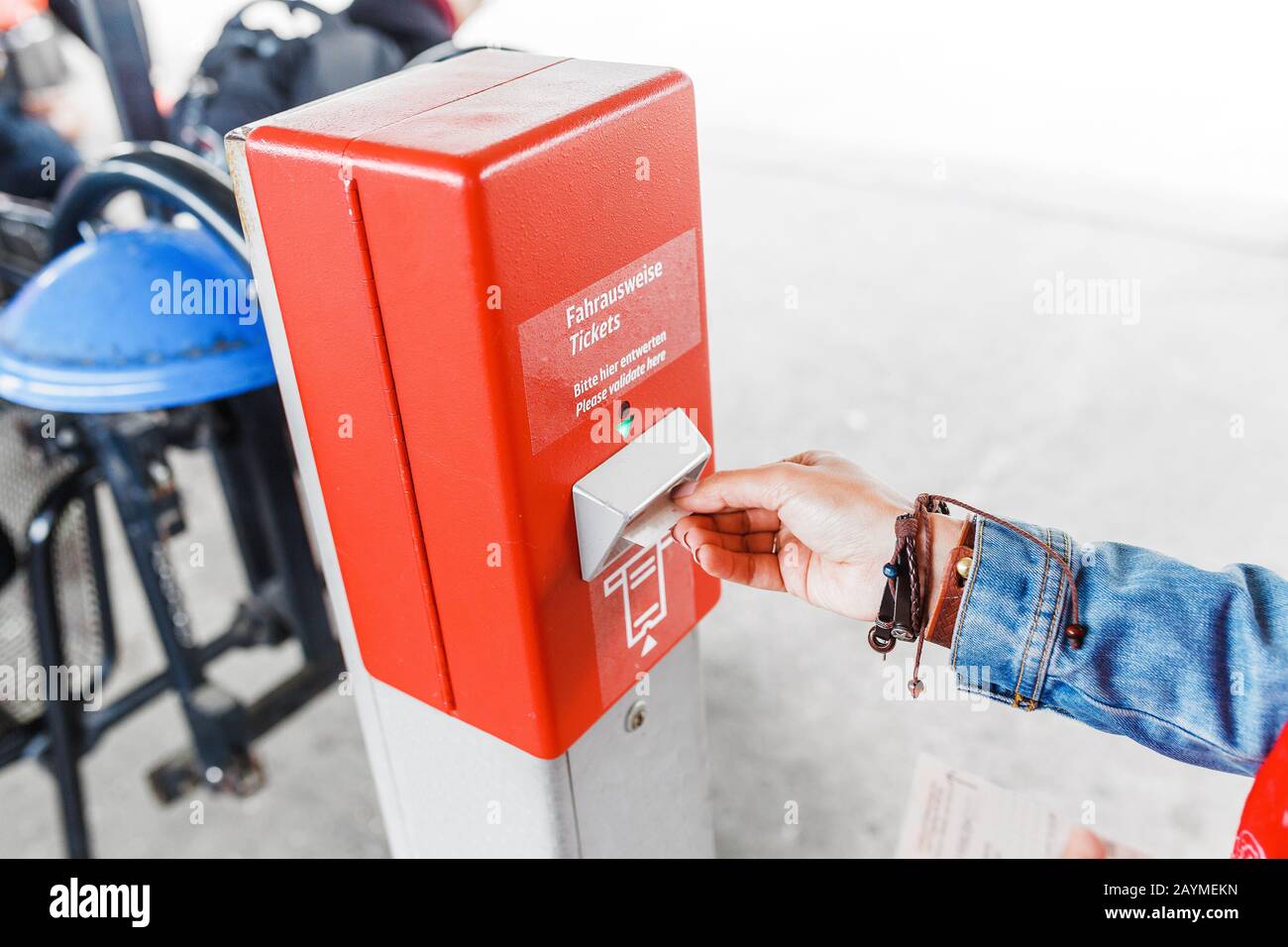 Woman at a ticket validator at subway station, public transport in ...