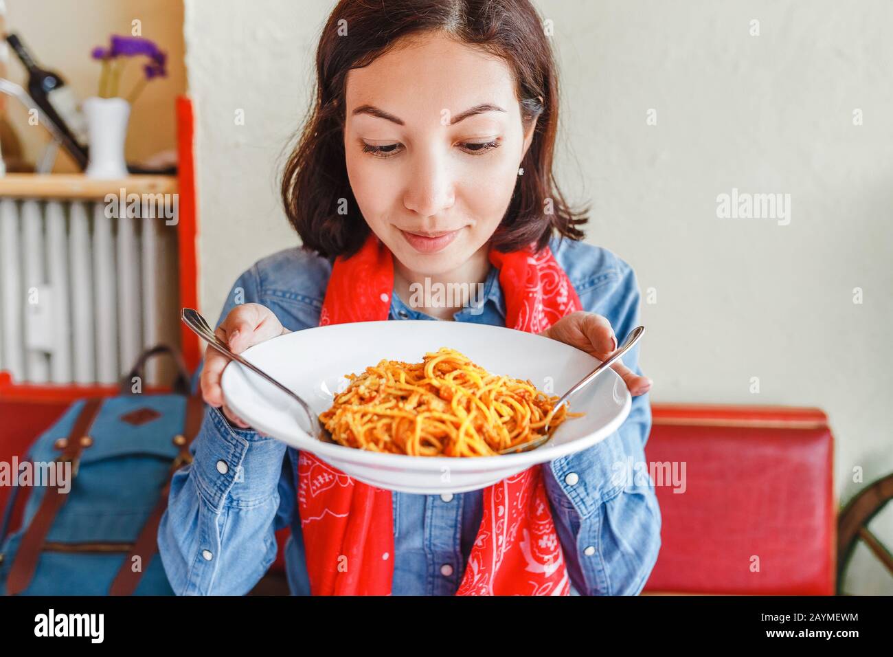 Young woman eating traditional italian pasta in local restaurant Stock