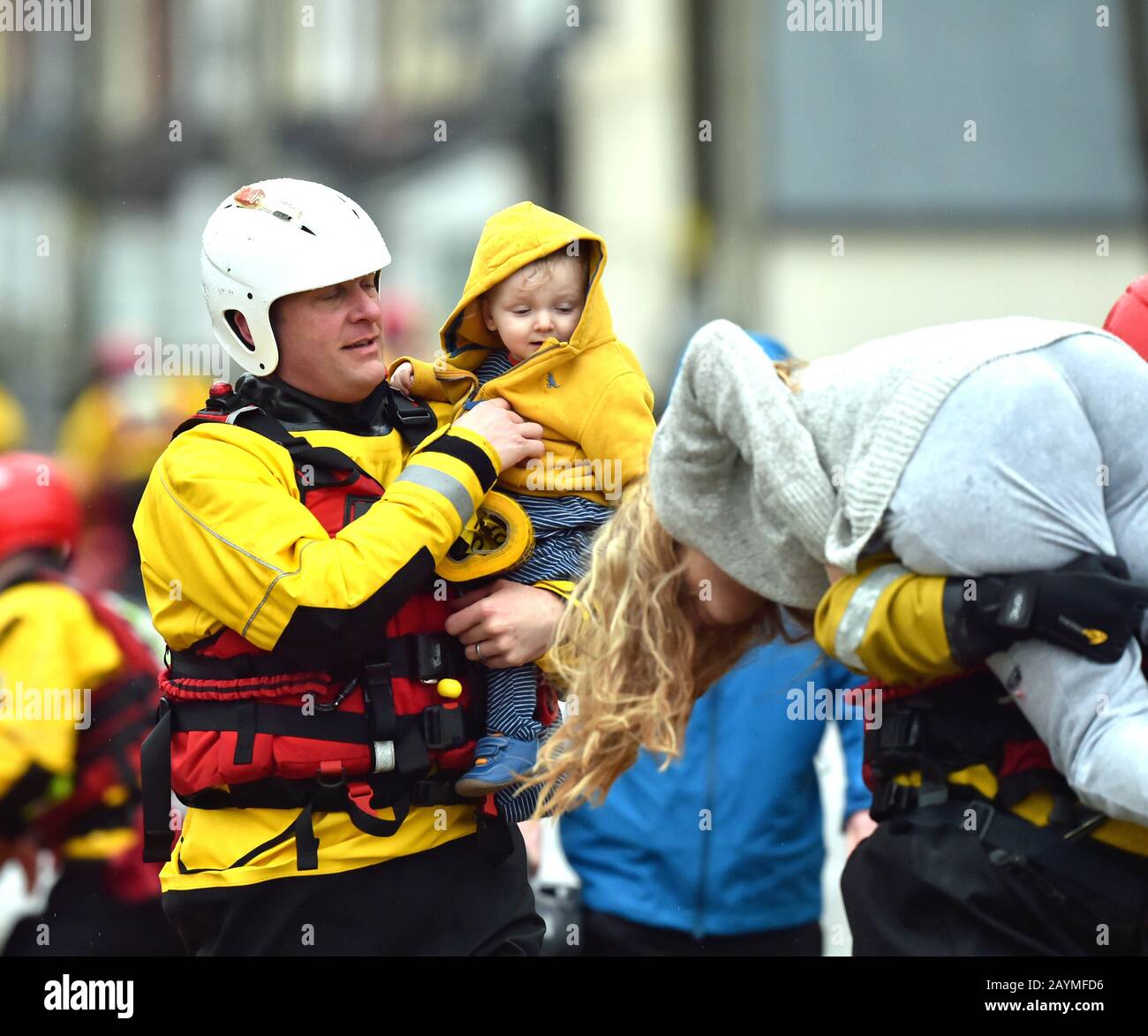 One-year-old Blake and his mum, Terri O'Donnel, are carried to safety as rescue operations continue, after flooding in Nantgarw, Wales, as Storm Dennis hit the UK. Stock Photo