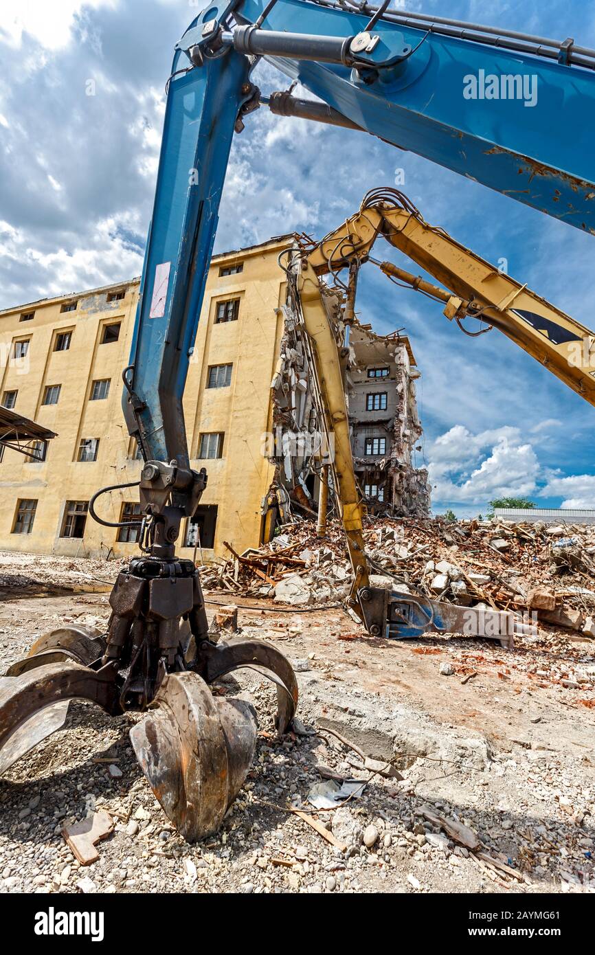 Ruins of demolished building. Heavy machinery surrounded with ruins. Construction industry concept. Stock Photo