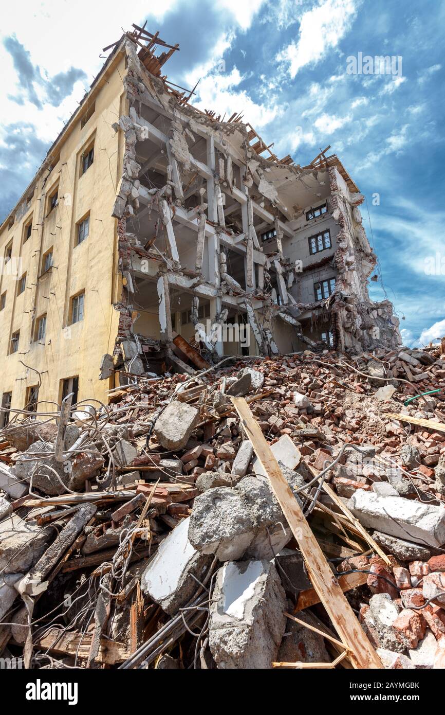 Ruins of demolished building. Heavy machinery surrounded with ruins. Construction industry concept. Stock Photo