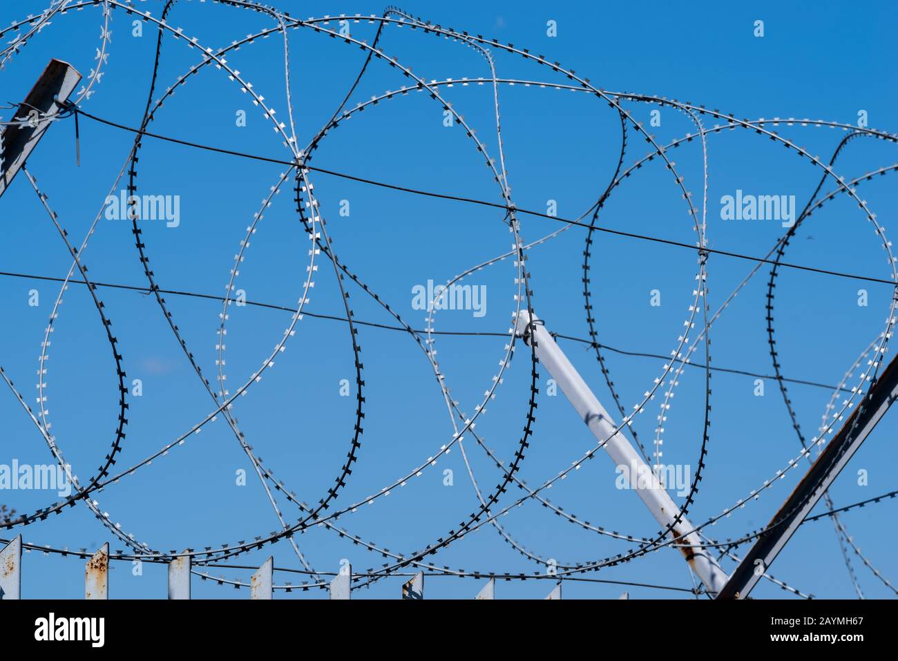 Barbed wire against the blue sky. Stock Photo