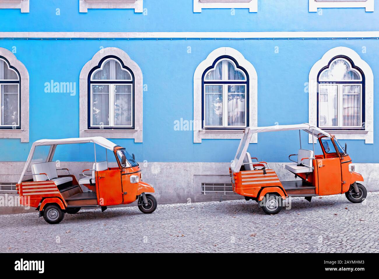 Tuk tuk vehicle in front of blue facade building in the Lisbon, Portugal. Tuktuk is traditional taxi on Thailand and popular Turistic transportation a Stock Photo