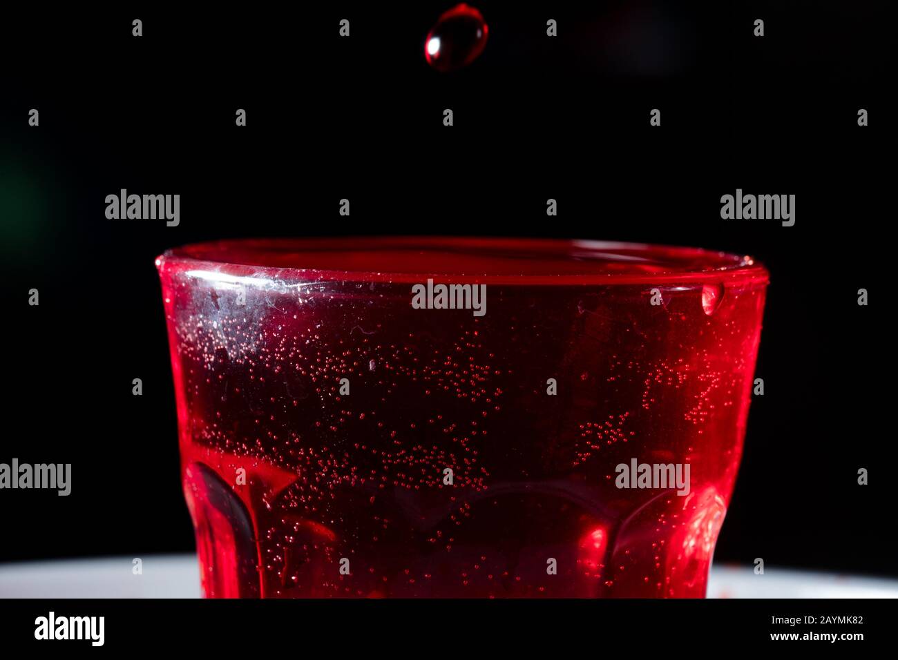 drops of red liquid in glass beaker Stock Photo Alamy