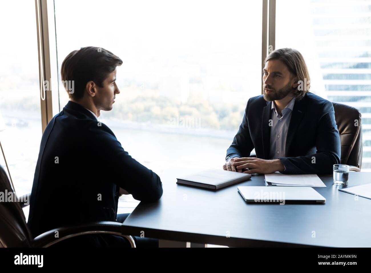 Serious businessman talking with mentor coach lead in office. Stock Photo