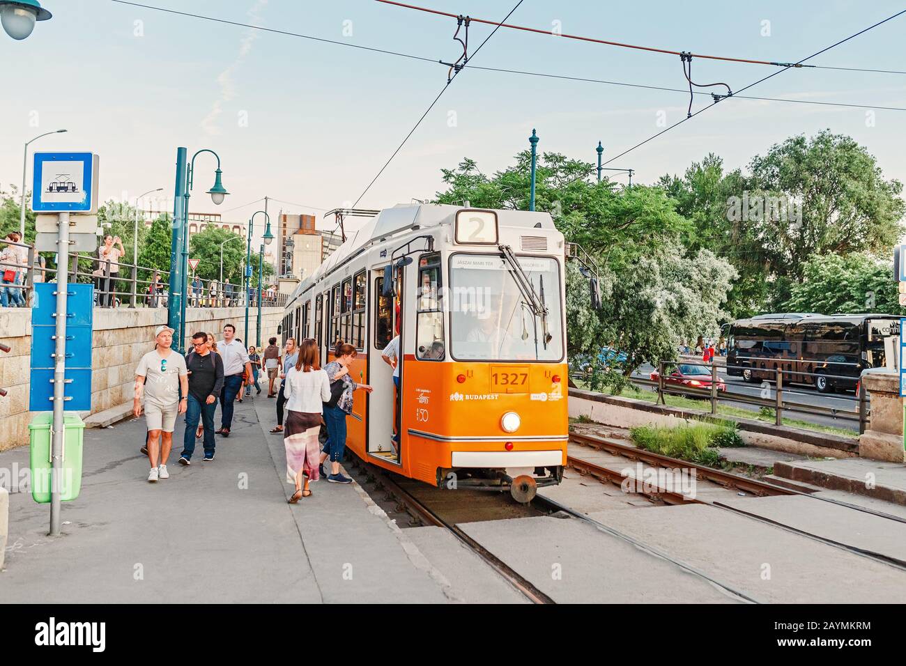 13 MAY 2018, BUDAPEST, HUNGARY: Passengers at the bus stop boarding in the yellow tram, the concept of public transport in Budapest Stock Photo