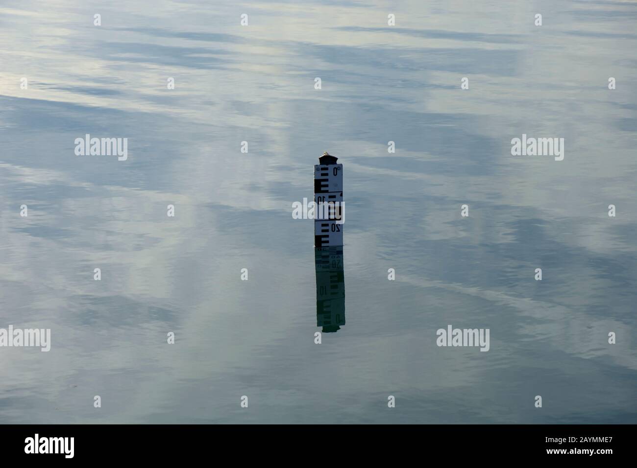 water level indicator show the depth of water in a lake, water depth sign on calm water surface Stock Photo