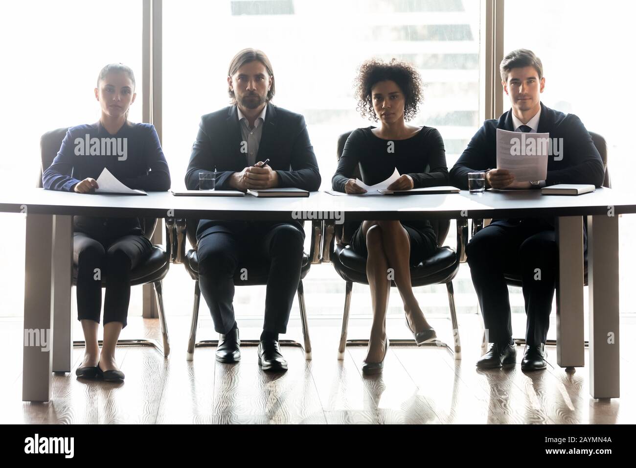 Diverse serious businessmen with applicant resume listening job seeker. Stock Photo