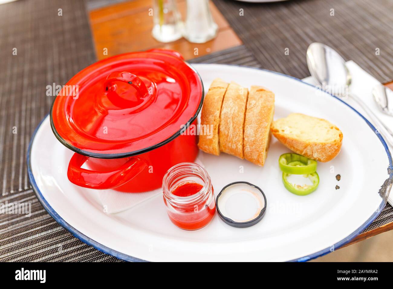Tasty goulash soup in red pot casserole on a restaurant table Stock Photo
