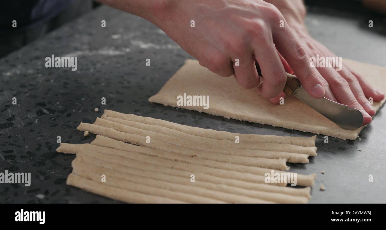 man cutting flat dough with knife, wide photo Stock Photo Alamy