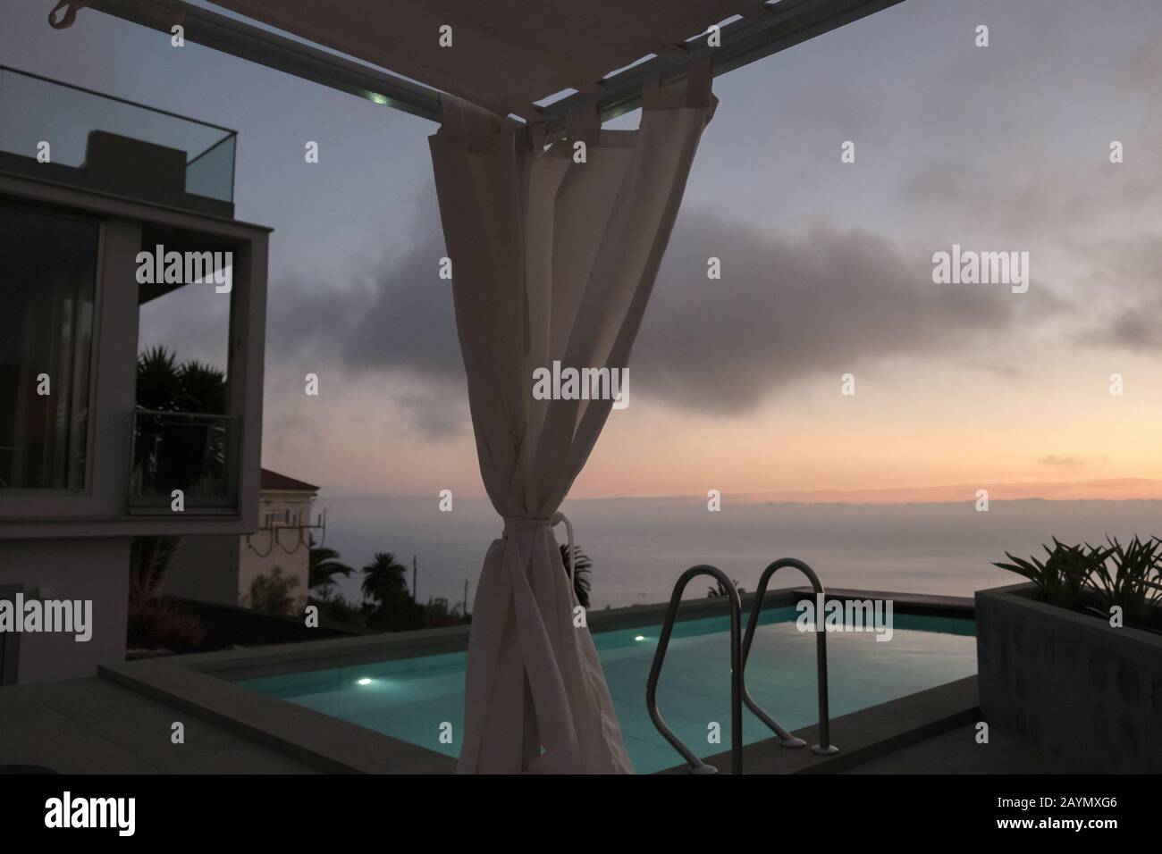 View of the swimming pool and the sea at dusk  from a luxury villa near La Punta, on La Palma, Canary Islands, Spain. Stock Photo