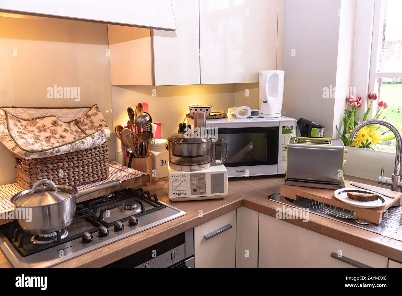 Cooking in a small kitchen - showing the economical use of space to cook homemade food, alongside its hazards. Stock Photo