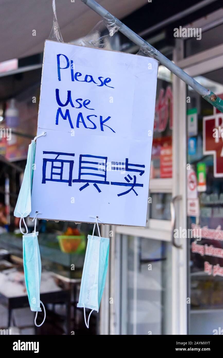A handwritten sign in English and Chinese asking people to wear face masks to stop the spread of Coronavirus, COVID-19, Phuket Old Town, Thailand. Stock Photo