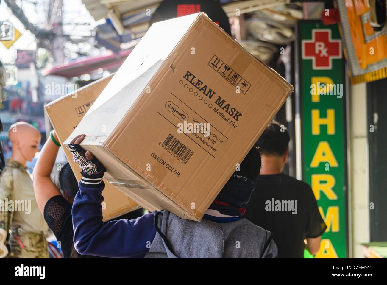 Men deliver large boxes of face masks to a pharmacy in Phuket Old Town during the Coronavirus COVID-19 pandemic, Bangkok. Stock Photo