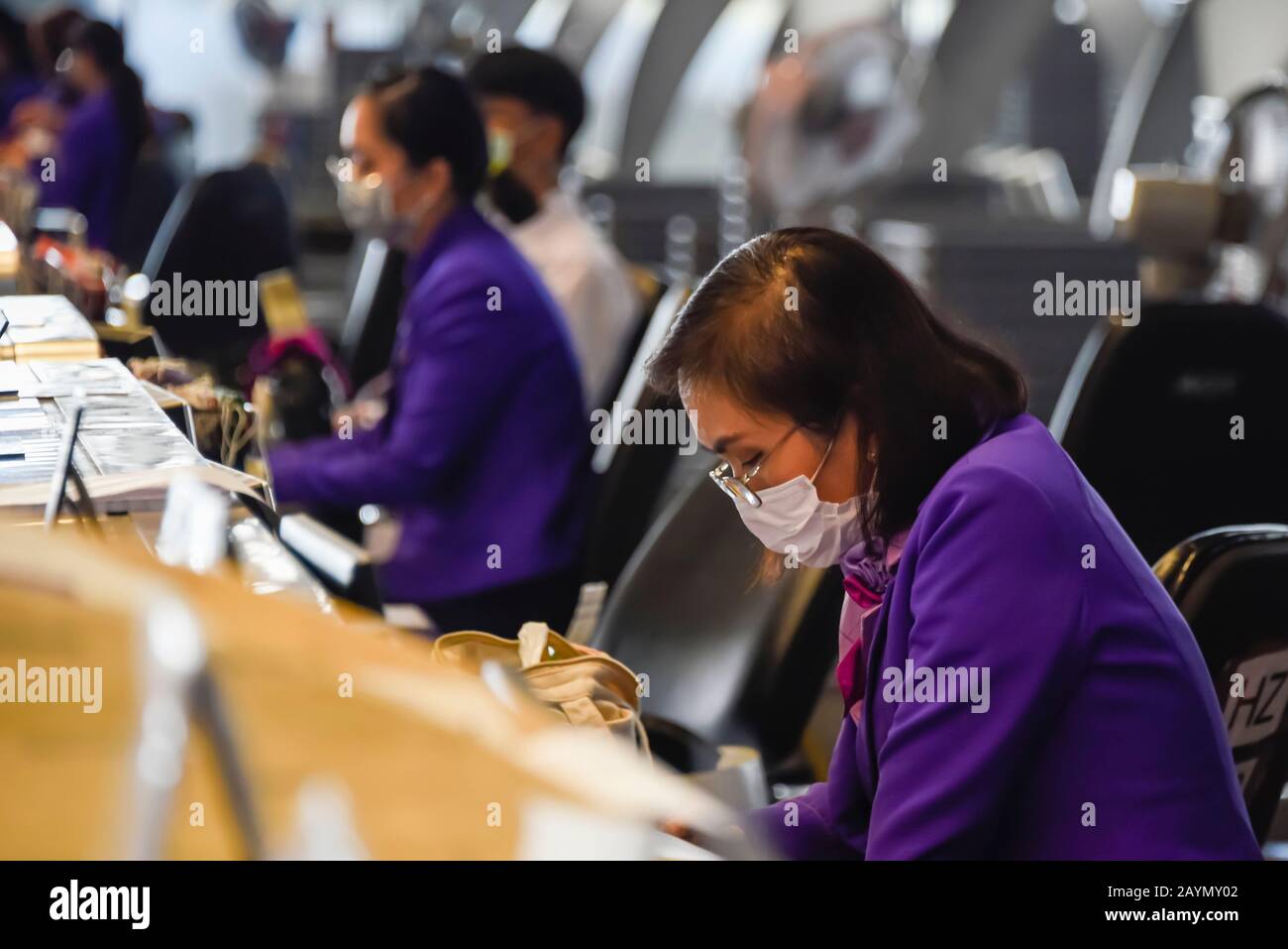 Checkin desk staff wear face masks to protect him against Coronavirus