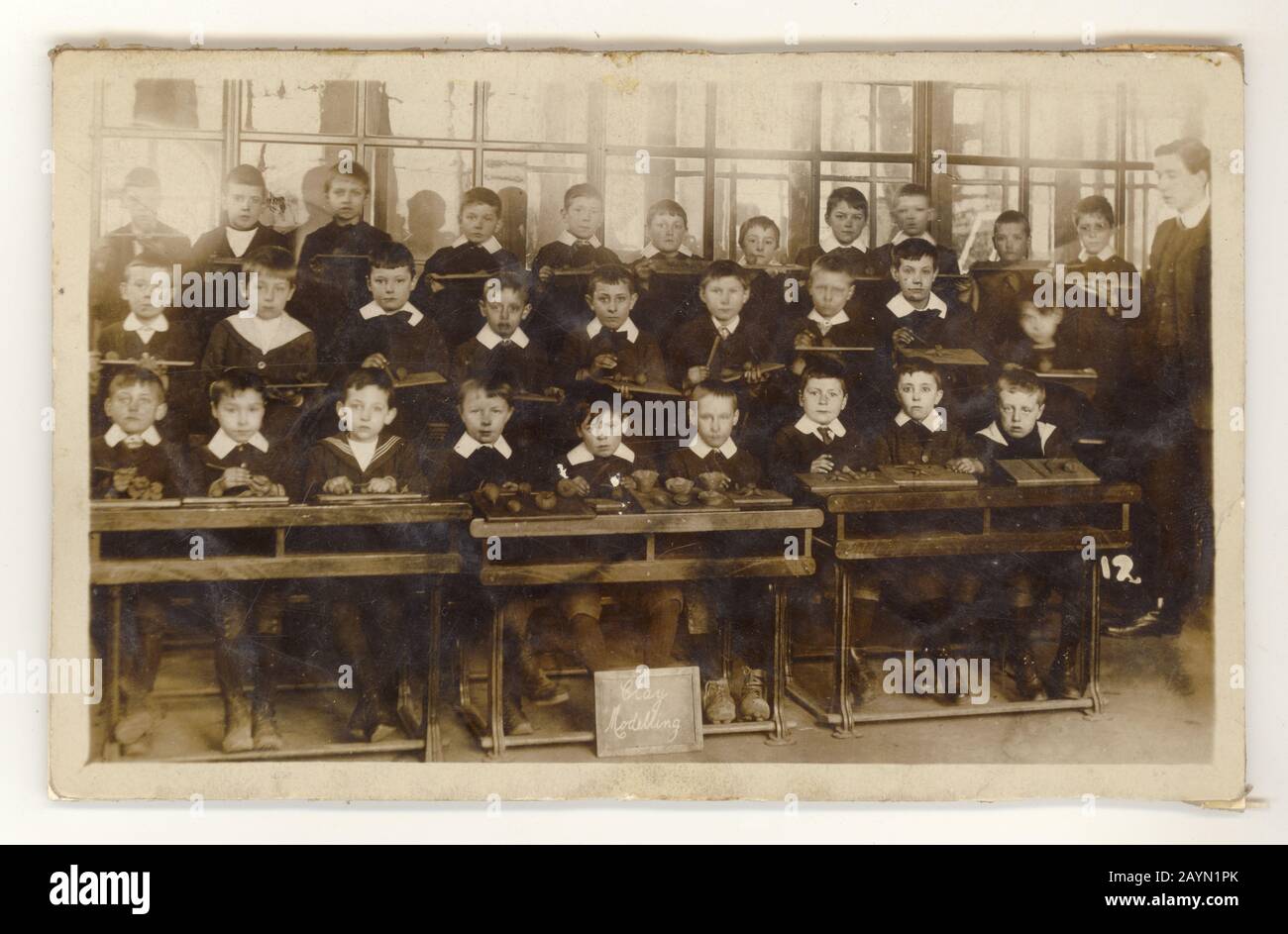 Faded Edwardian postcard of schoolboys in classroom, sitting at rows of desks, modelling clay, on reverse is J.L. Maltby, Winchester, Hampshire, England,  U.K. circa 1905 Stock Photo