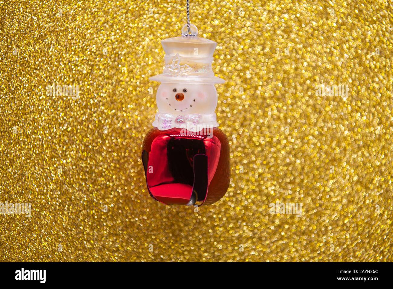 Christmas Snowman bell with glittery golden back ground. Stock Photo