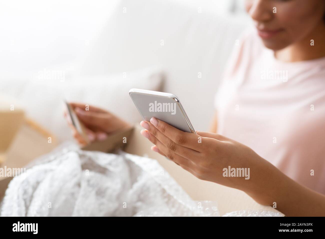 Afro girl shopping online with mobile phone and credit card Stock Photo