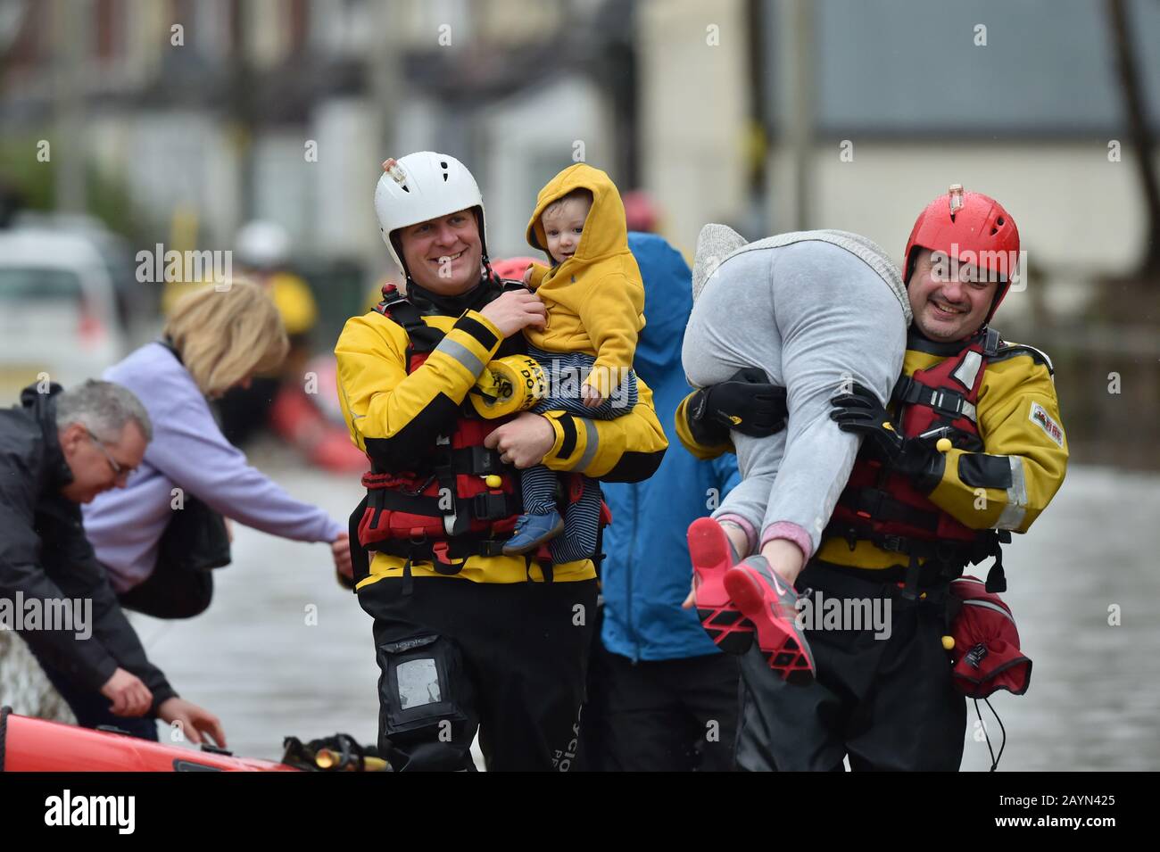 One-year-old Blake is handed to his mum, Terri O'Donnel, by a rescue worker as emergency services continue to take families to safety, after flooding in Nantgarw, Wales, as Storm Dennis hit the UK. Stock Photo