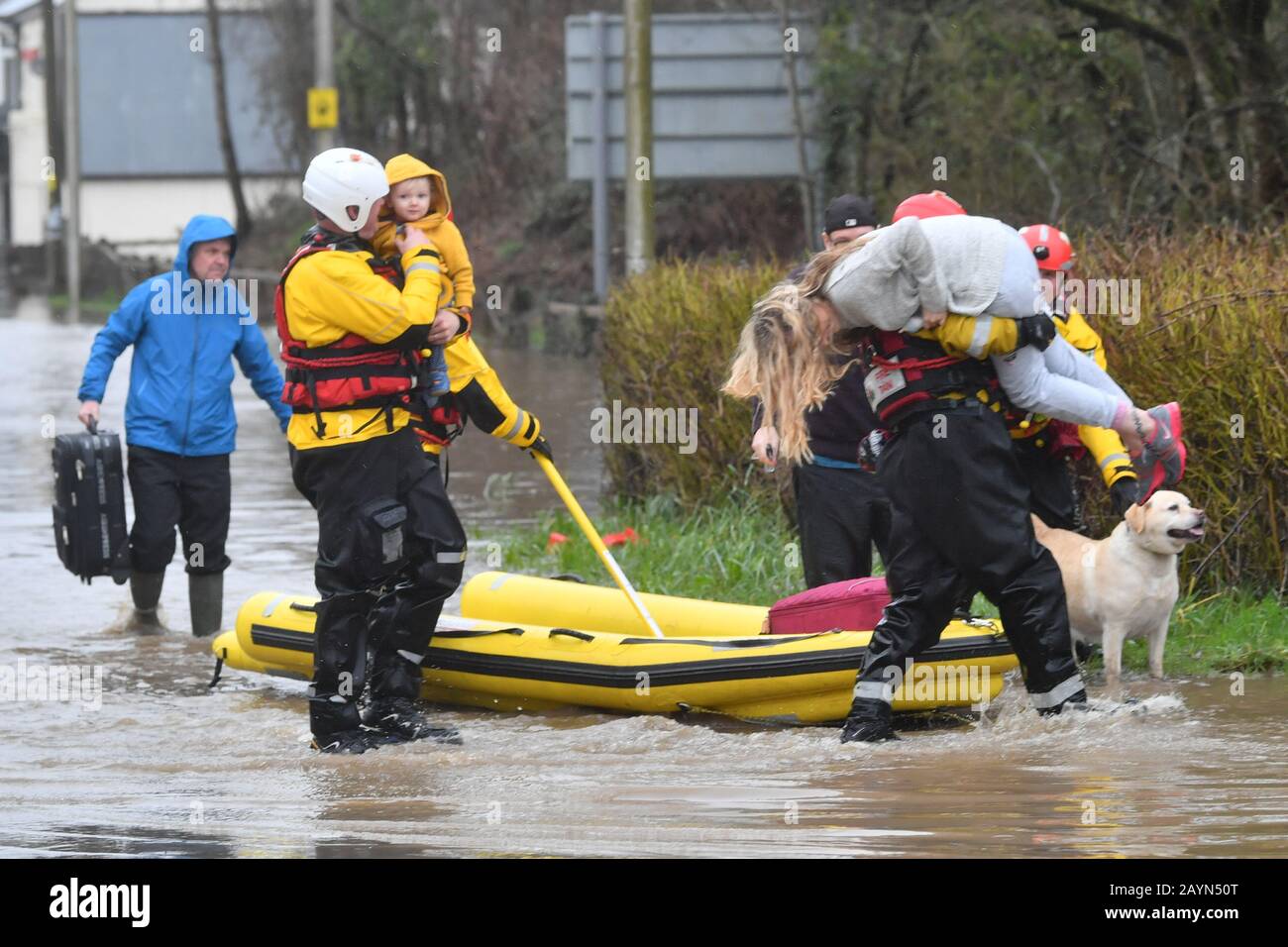 One-year-old Blake and his mum, Terri O'Donnel, are carried to safety by rescue workers as emergency services continue to take families to safety, after flooding in Nantgarw, Wales, as Storm Dennis hit the UK. Stock Photo