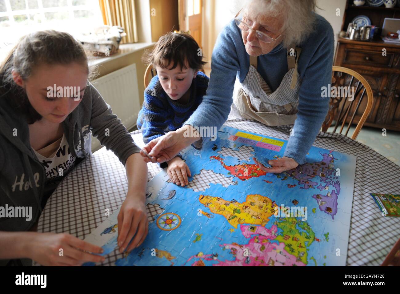 Grandmother doing a jigsaw with her grandchildren, Uk. Stock Photo