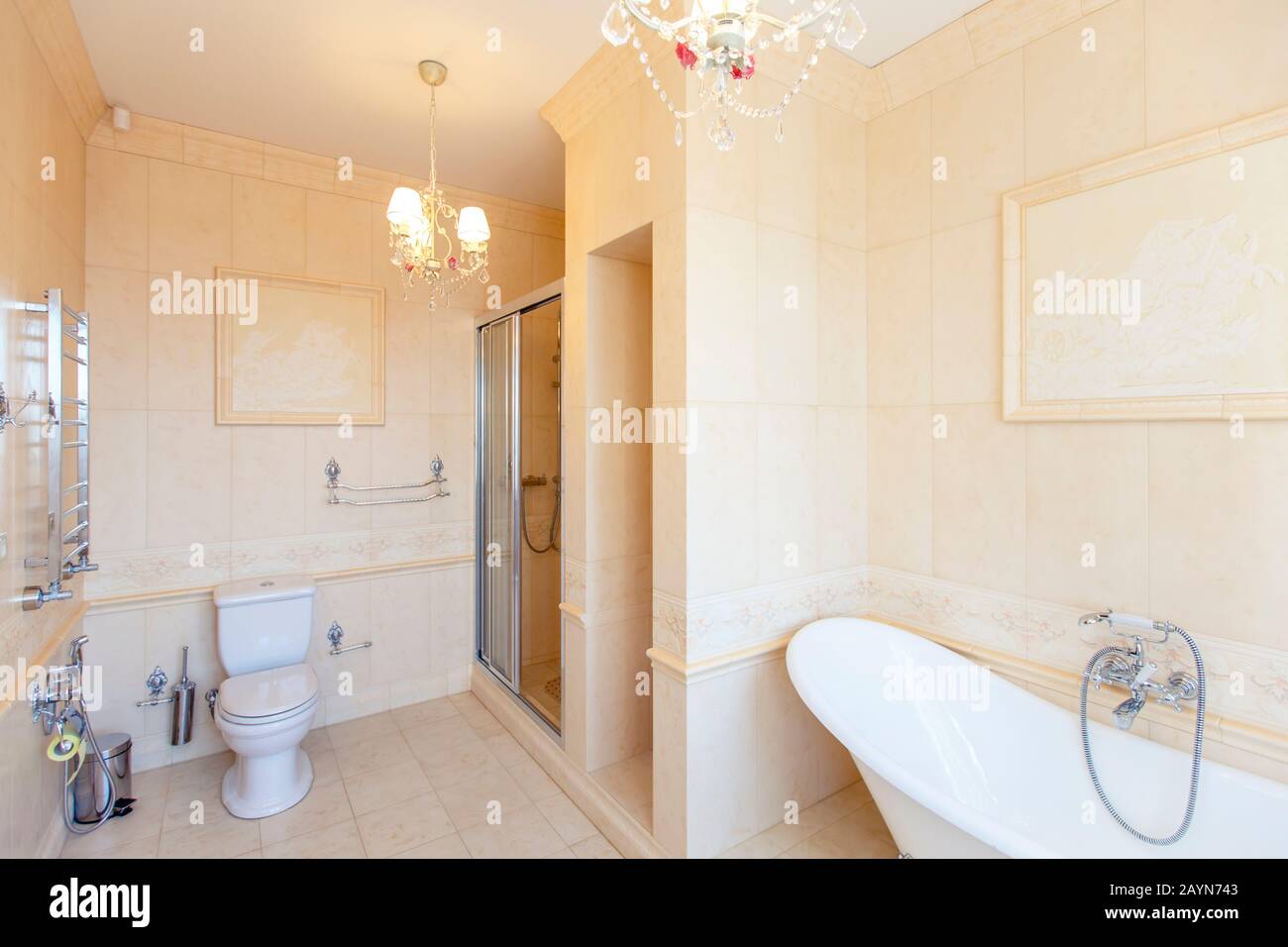 Classic bathroom in beige tones. Curved bath tub. Large beige tile
