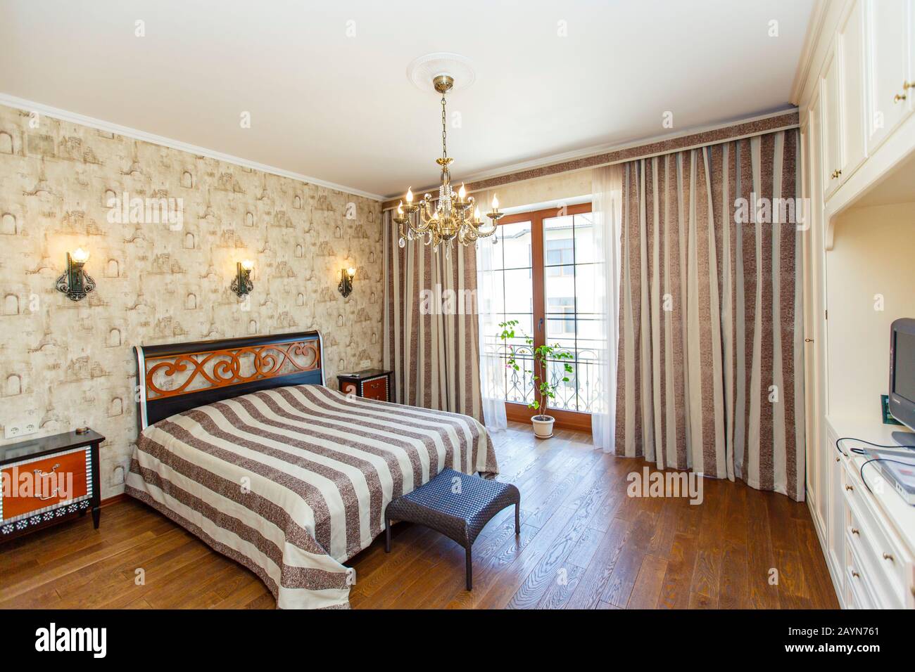 Classic Bedroom With Beige Wallpaper A Large Bed With A Bedspread With Black Stripes White Bedside Tables With Red Drawers The Lamp On The Walls Stock Photo Alamy