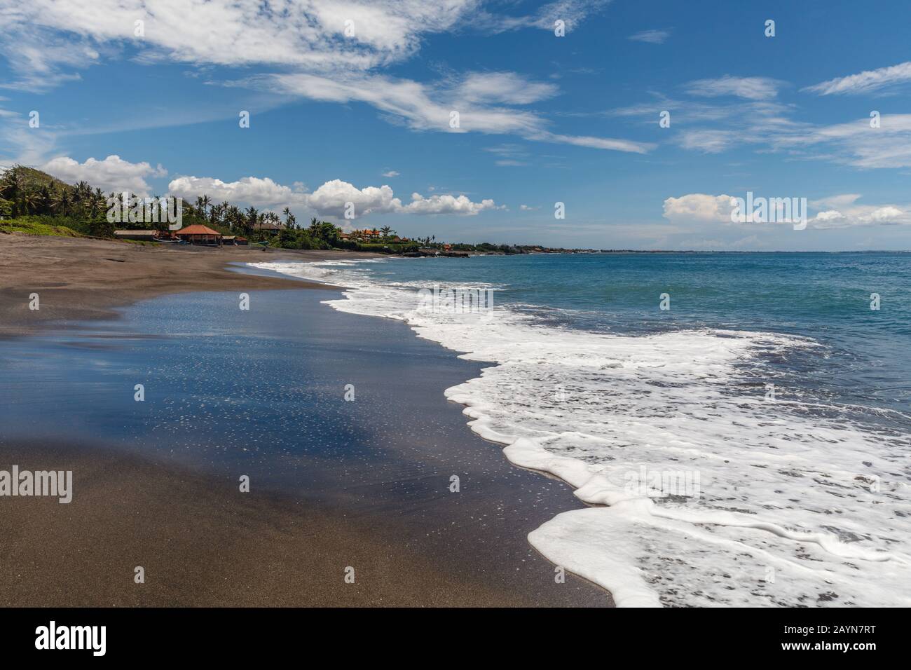 View of Pantai Babadan (Babadan beach), Canggu, Bali, Indonesia. Volcanic black sand, ocean waves, palm trees. Stock Photo