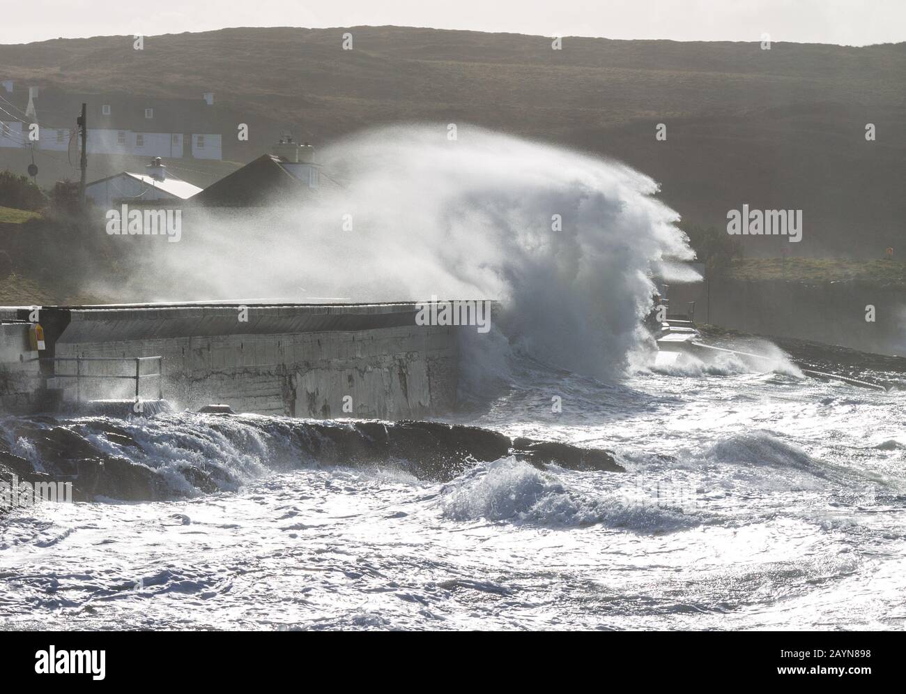 waves breaking over sea wall or coastal defence in west cork Ireland Stock Photo