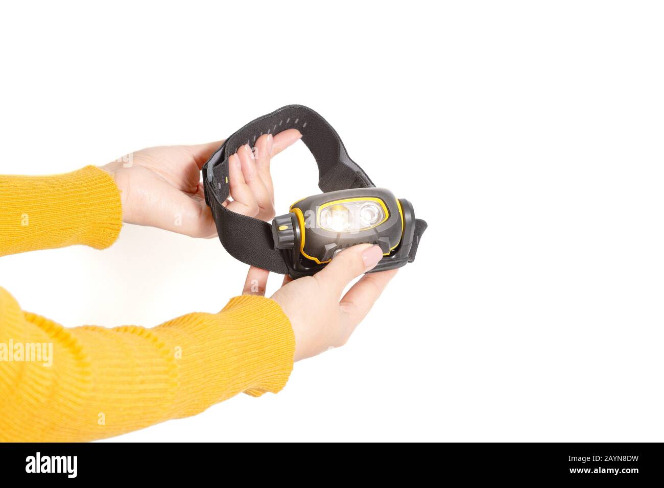 Head lamp flashlight with light beam in woman hands Stock Photo