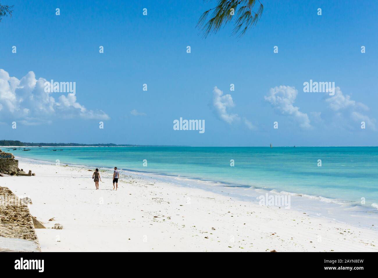 beautiful beach and tropical sea with two idefinite turists in Jambiani, Zanzibar, Tanzania Africa Stock Photo