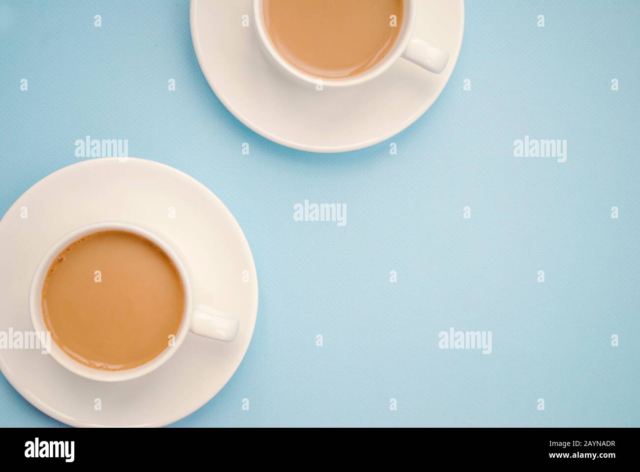 Two white cups coffee with milk, light blue background, top view. Americano. Copy space Stock Photo