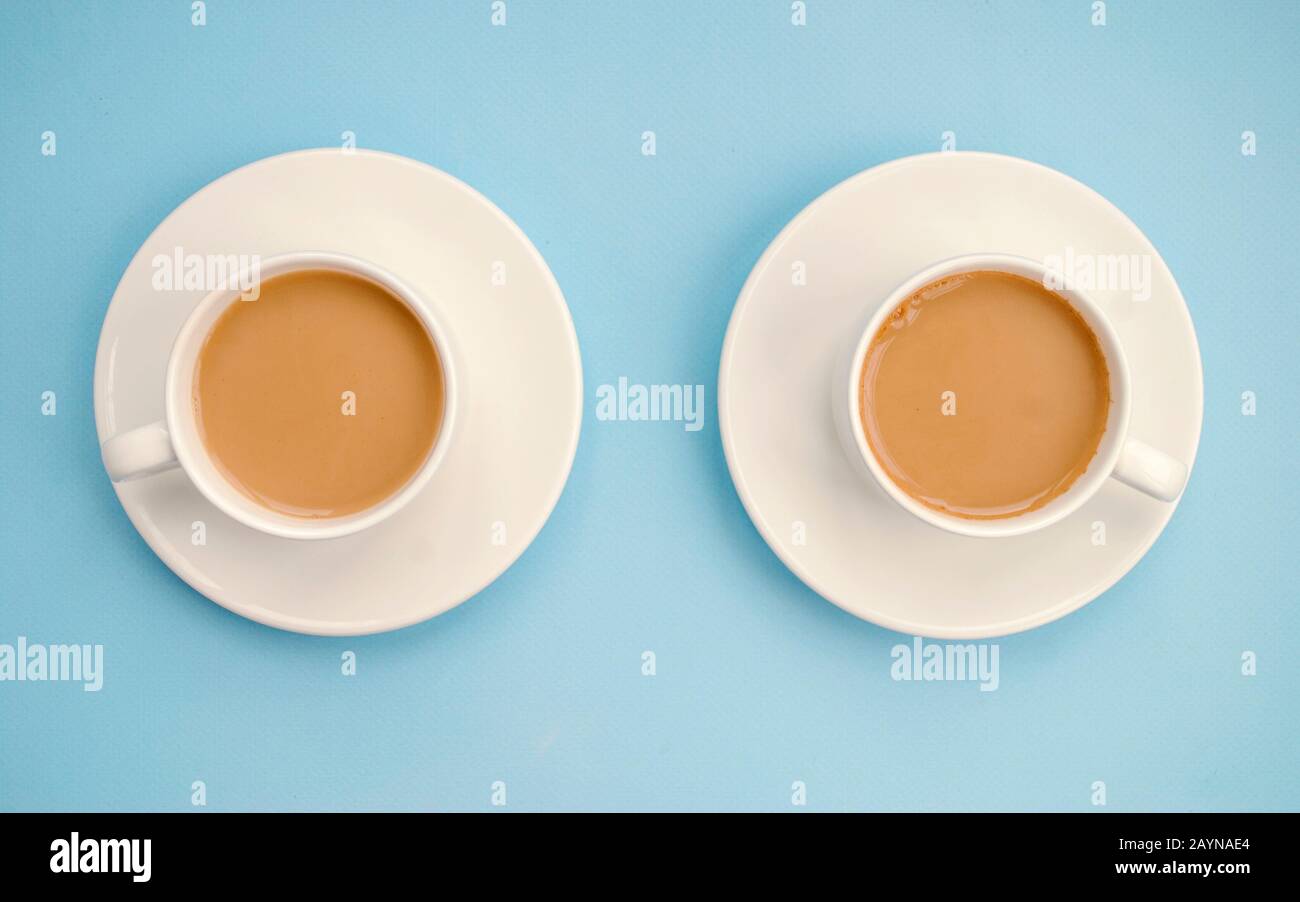 Two white cups coffee with milk, light blue background, top view. Americano. Copy space Stock Photo