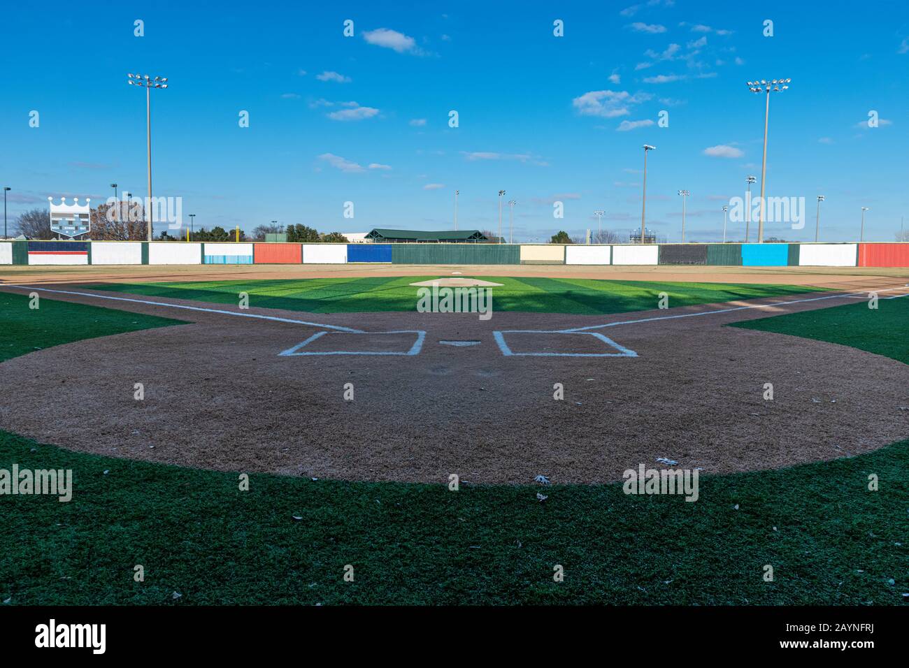 View of a baseball field with artificail turf as seen from behind home plate and looking out across the pitcher's mound to the outfield. Stock Photo