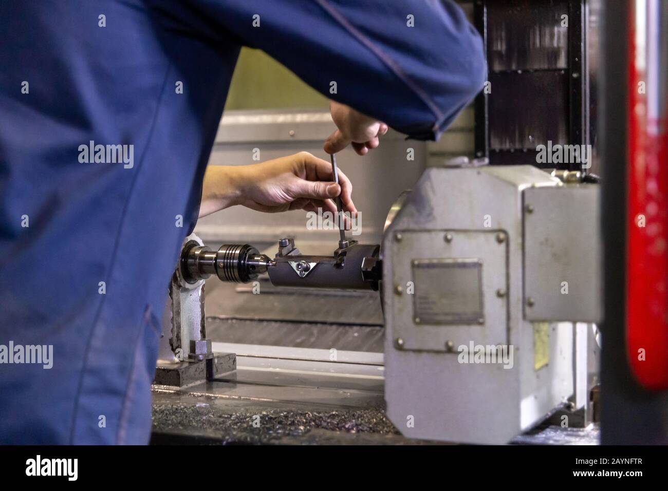 operator twisting bolts on fixture clamps inside of cnc milling machine
