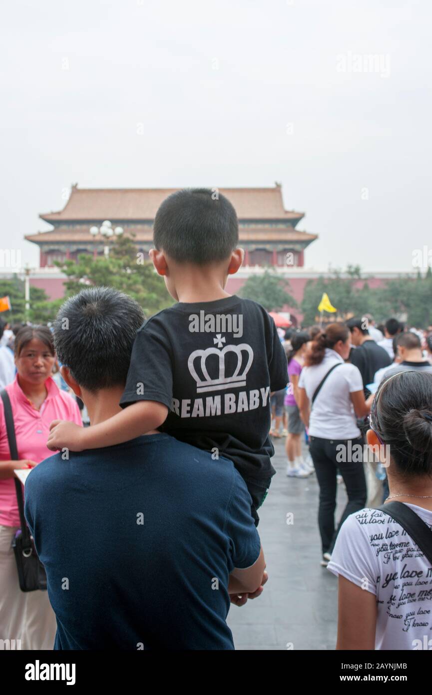 Chinese father carrying his son with a dream baby t-shirt (one child only policy) visiting the Forbidden City in Beijing, China. Stock Photo
