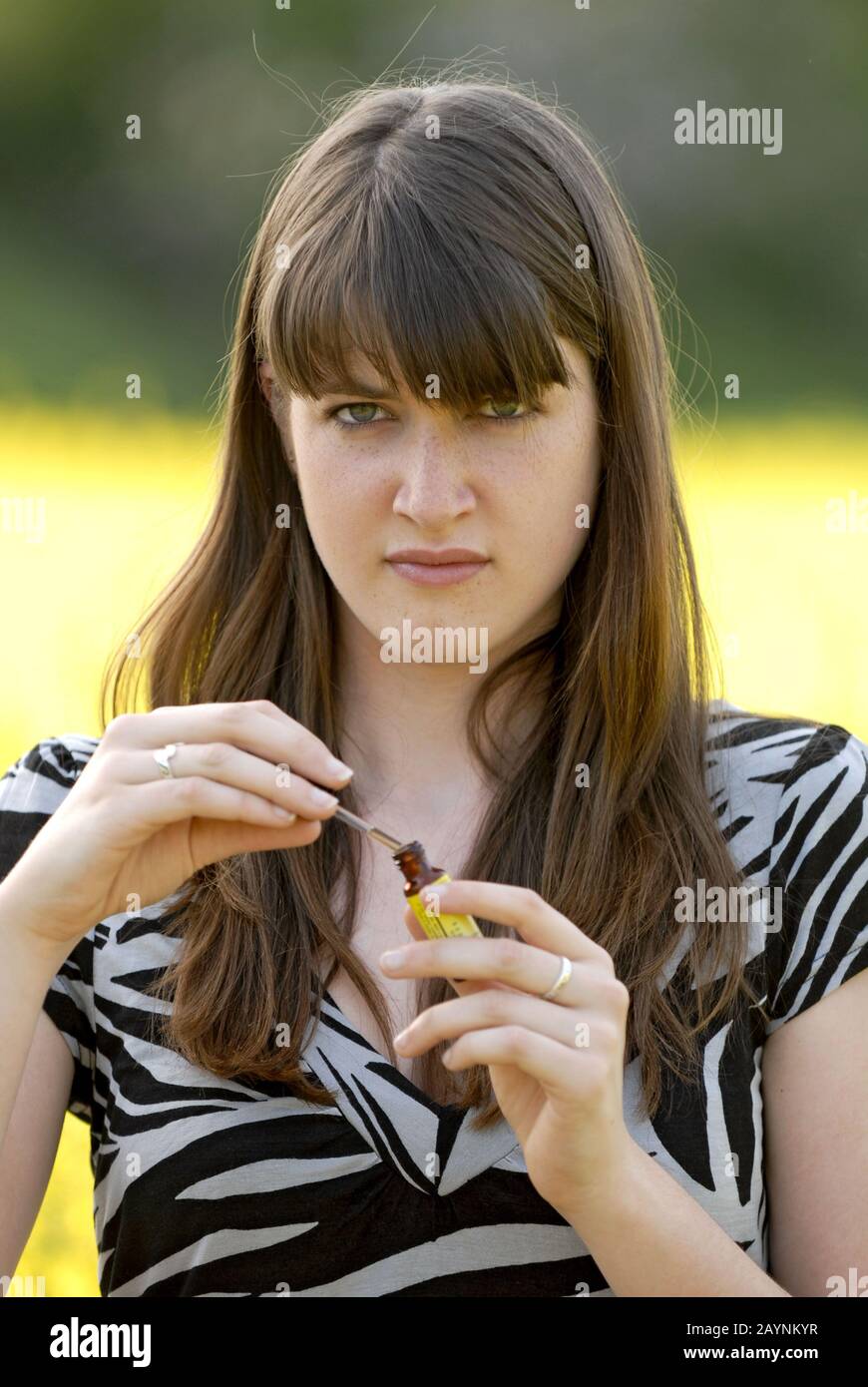 Junge Frau nimmt Tropfen gegen Heuschnupfen Stock Photo