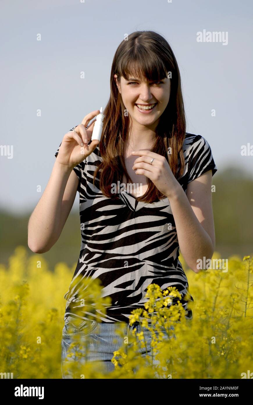 Junge Frau nimmt Nasenspray gegen Heuschnupfen Stock Photo
