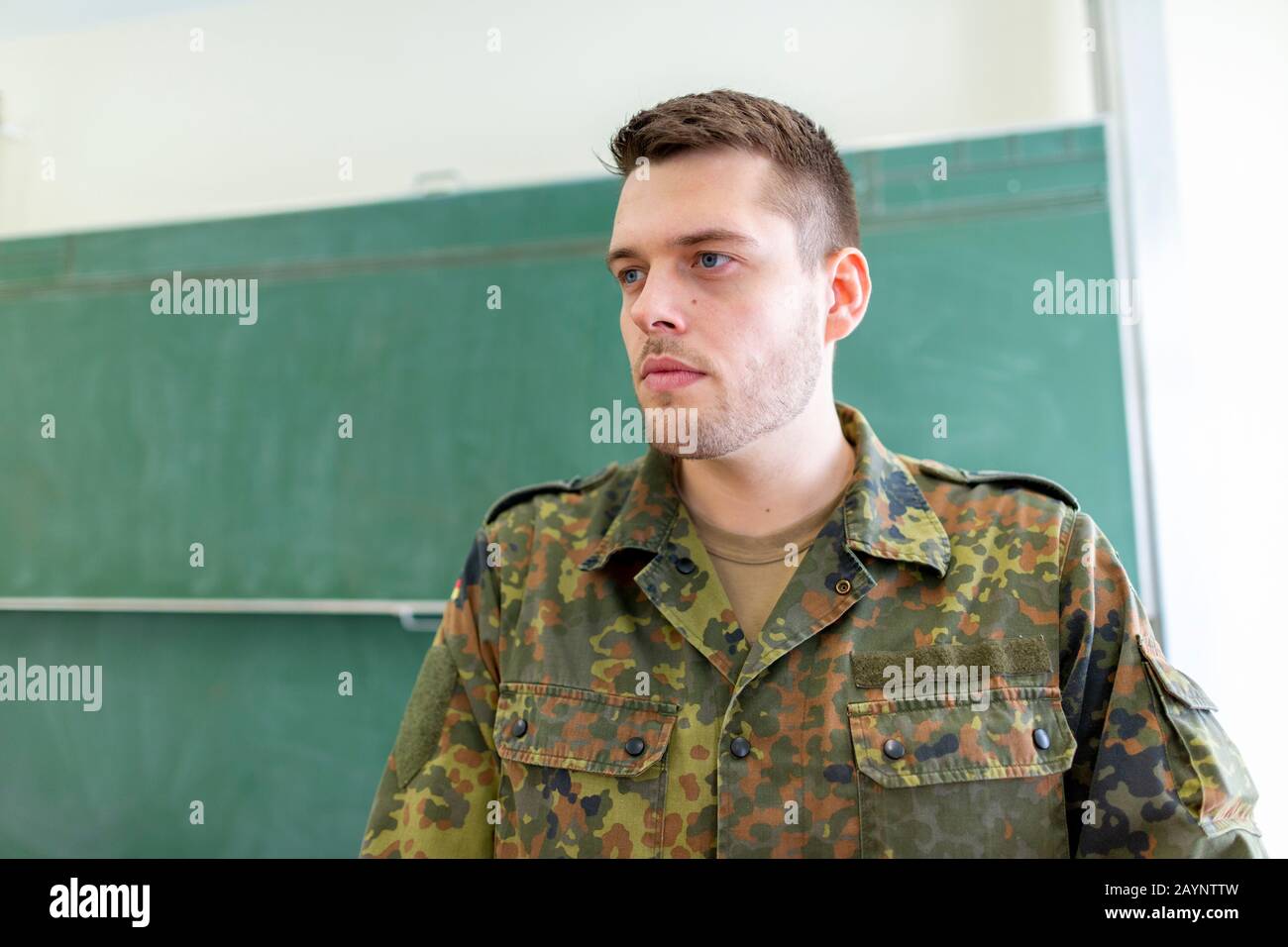 German soldier stands in a classroom . German word Bundeswehr, means ...