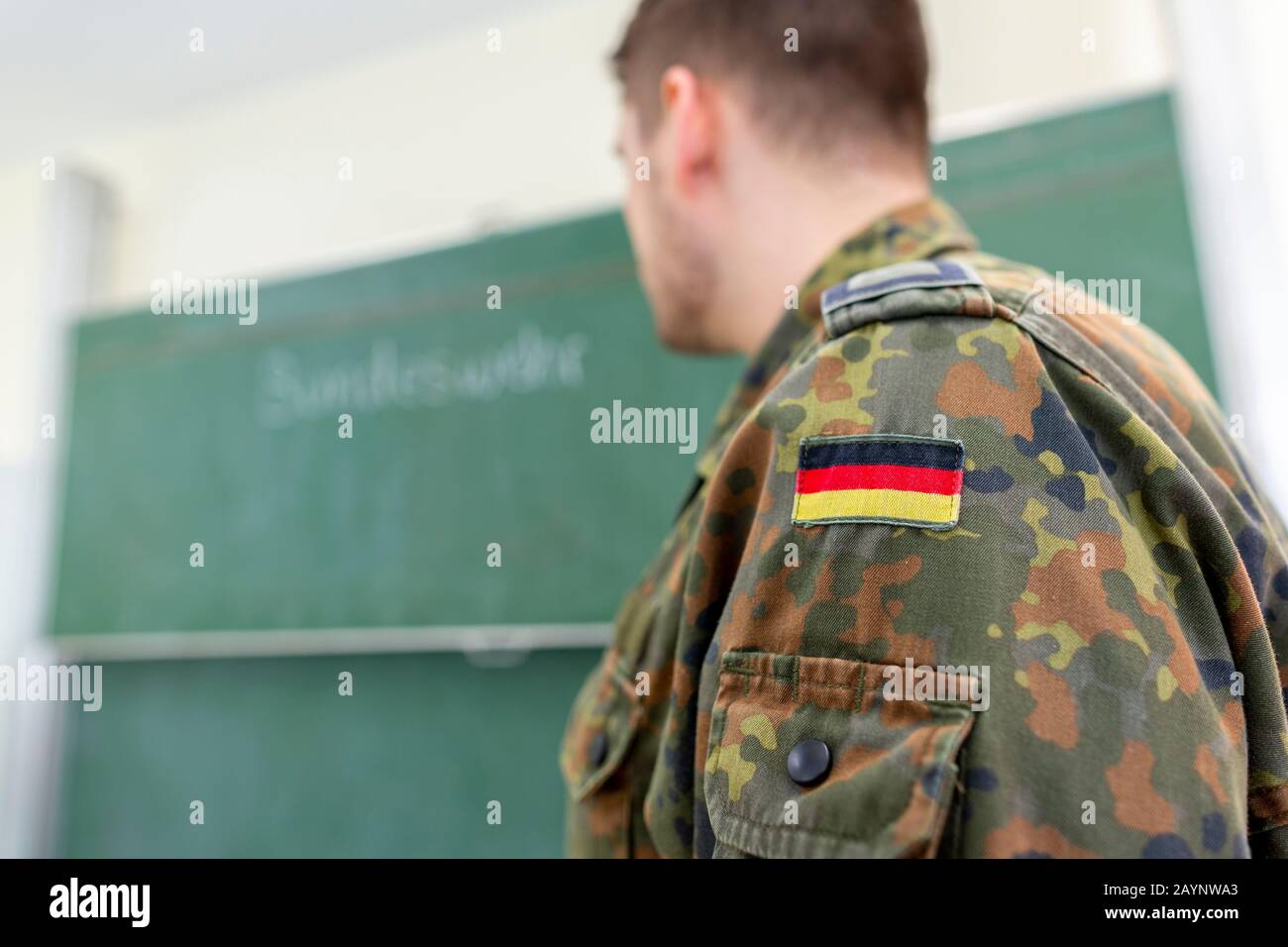 German soldier stands in a classroom . German word Bundeswehr, means ...