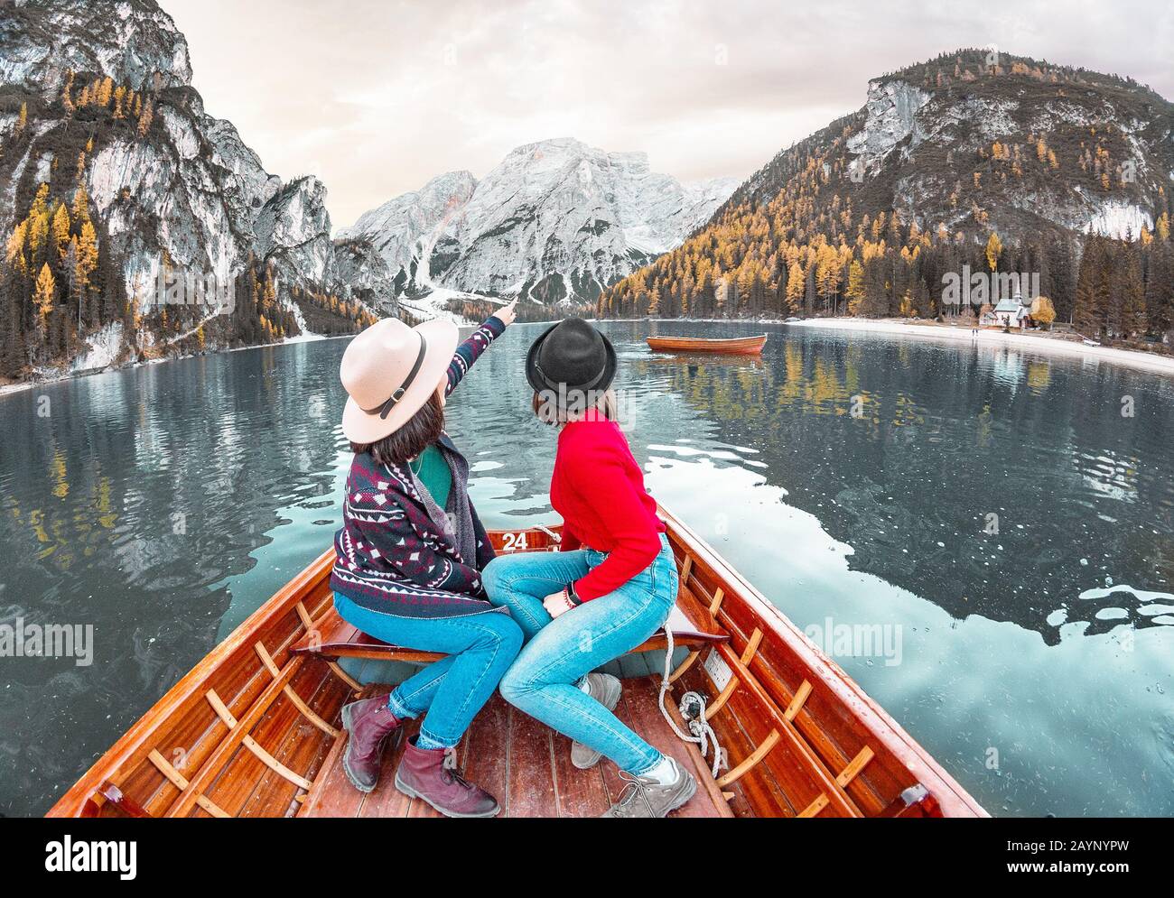 Two happy woman friends on the boat or canoe cruise tour on lago Di Braies lake in Italian Dolomites Alps Stock Photo