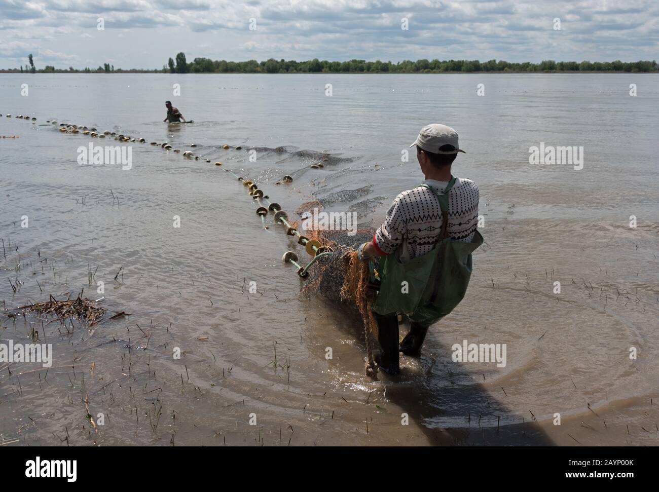 Fishermеn drag and trawls the fishing net with fish in the river