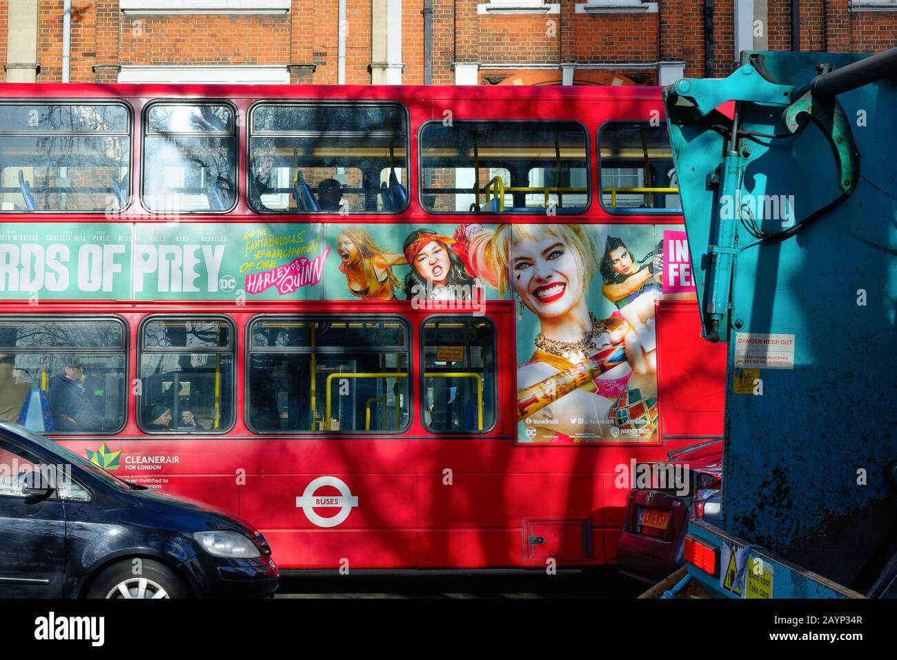 An advertising image with faces on the side of a red London Bus Stock Photo