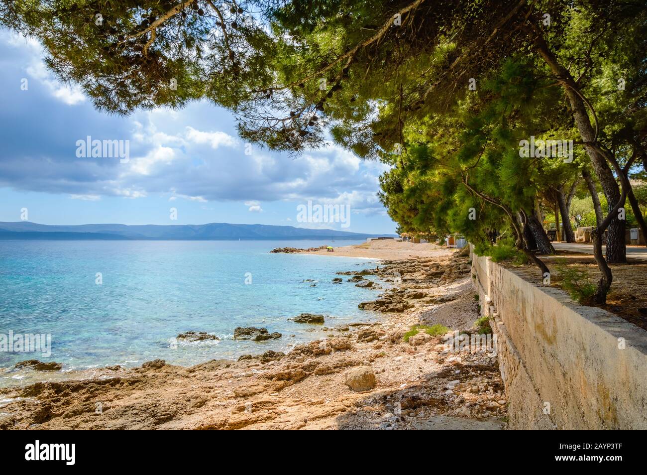 Coastline in Bol, Brac island, Croatia. Scenic view with pine trees, mountains and turquoise water of Adriatic Sea on sunny day. Famous tourist destin Stock Photo