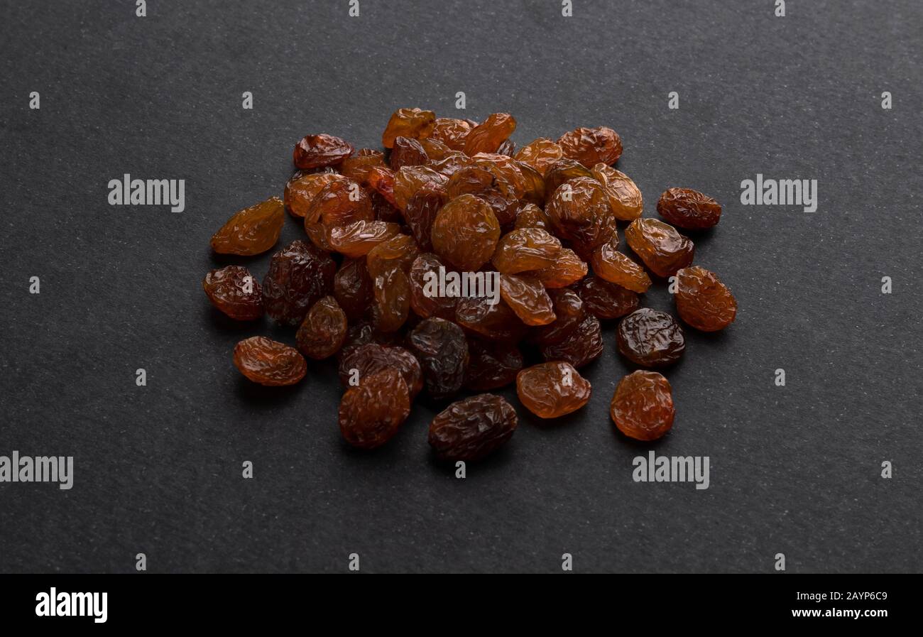 Dried raisins on black background Stock Photo
